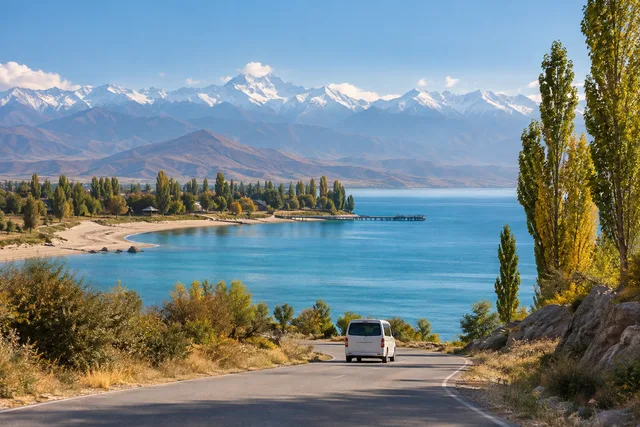Illustrazione generata con IA di un minivan sulla sponda nord di Issyk-Kul, vicino a Cholpon-Ata